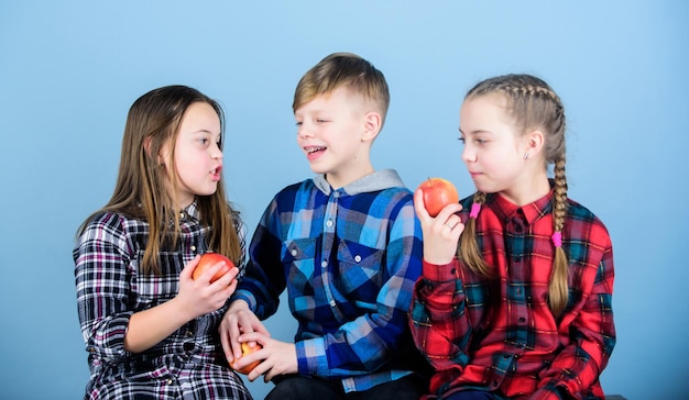 Promouvoir une alimentation saine Amis garçons et filles mangent des pommes Adolescents avec une collation saine Groupe d'adolescents joyeux enfants tenant des pommes Régime alimentaire sain et nutrition vitaminique Mangez des fruits et soyez en bonne santé