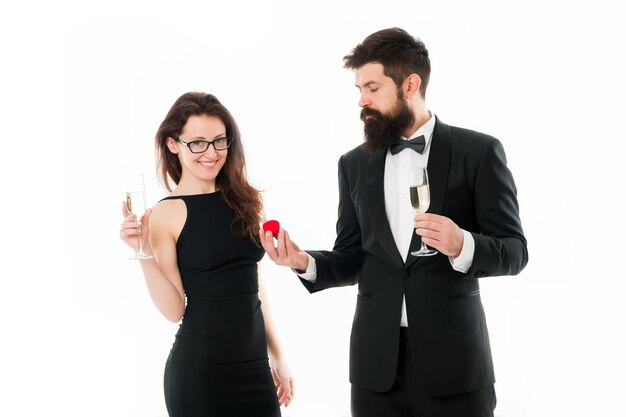 Proposition de mariage. homme barbu en smoking fait une proposition à une femme sexy. couple amoureux célèbre les fiançailles avec du champagne dans des verres. couple heureux célébrant leur amour. La Saint-Valentin. Aimer.