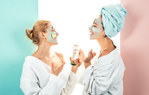 Propre salon de spa à la maison conception des soins de la peau en utilisant un masque blanc et des concombres sur le visage deux fema