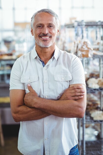 Propriétaire de boulangerie souriant debout avec les bras croisés