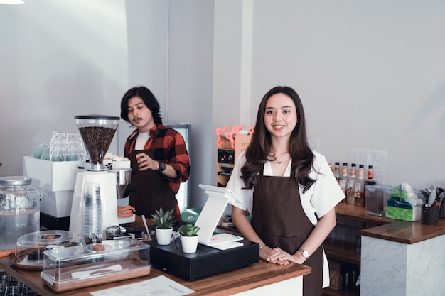 Propriétaire de café asiatique souriant à la caméra