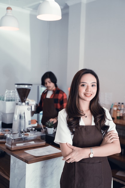 Propriétaire de café asiatique souriant à la caméra