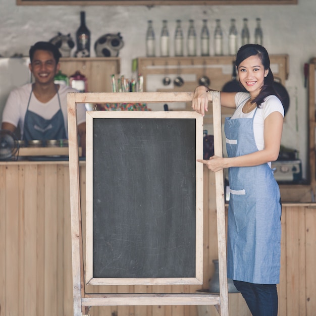 Propriétaire de café femme asiatique avec tableau blanc