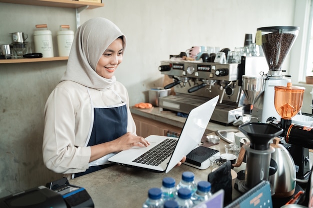 Propriétaire de café hijab femmes utilisent un ordinateur portable