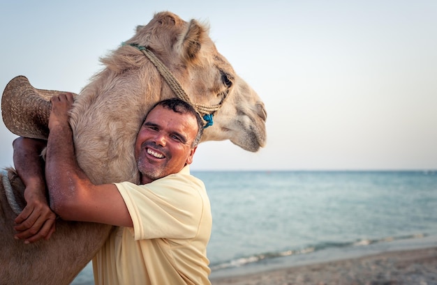 Propriétaire de chameau sur la côte tunisienne avec son chameau closeupxA