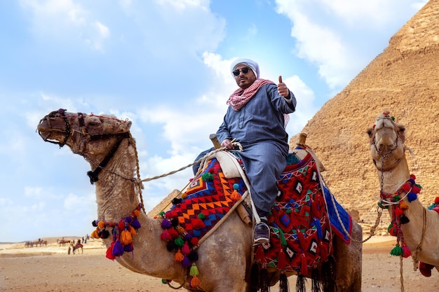 Propriétaire de chameau offrant une visite autour des pyramides