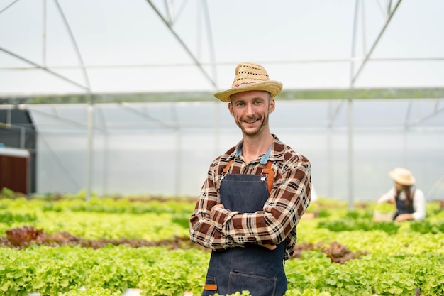 Le propriétaire du potager hydroponique vérifie la qualité des légumes et vérifie ou enregistre la croissance des légumes dans le jardin Légumes dans la serre