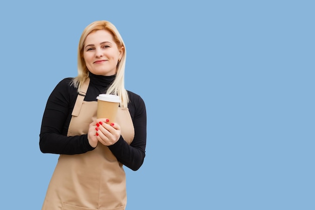 Propriétaire d'un emploi à temps partiel mode de vie routinier de cacao pause de repos détente concept de pause de loisirs. Portrait d'une gentille fille agréable et sympathique donnant un grand latte isolé sur fond bleu copie-espace.