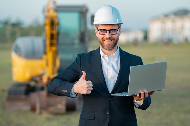 Propriétaire d'entreprise de construction Homme en costume et casque de sécurité sur le chantier de construction Civil