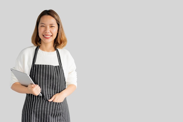 Propriétaire d'entreprise femme asiatique tenir tablette isolé sur fond gris