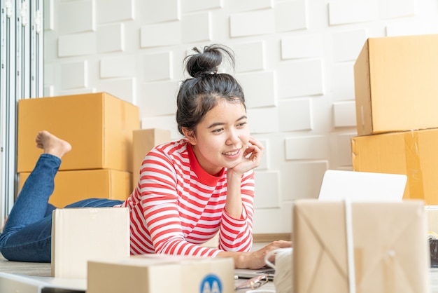 Propriétaire d'entreprise femmes asiatiques travaillant à la maison avec boîte d'emballage sur le lieu de travail