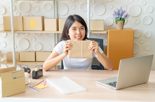 Propriétaire d'entreprise femmes asiatiques travaillant à la maison avec boîte d'emballage sur le lieu de travail