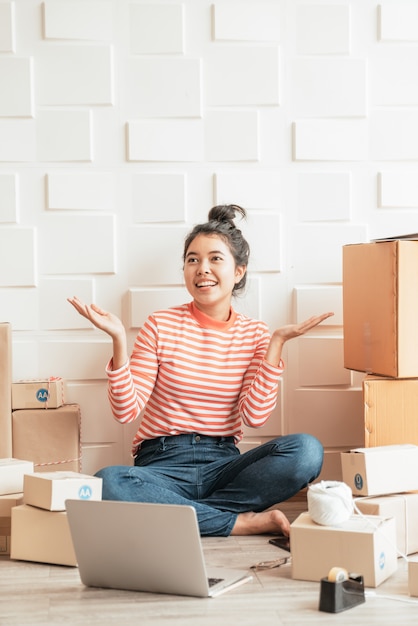 Propriétaire d'entreprise femmes asiatiques travaillant à la maison avec boîte d'emballage sur le lieu de travail