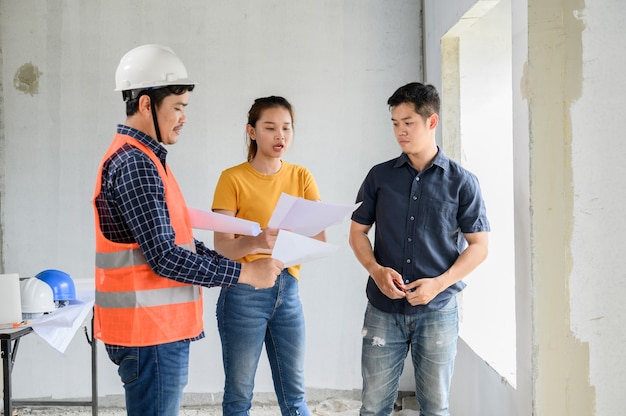 Propriétaire d'une maison neuve inspection avec ingénieur et architecte. Couple d'amour au projet de village et à la construction d'un domaine.