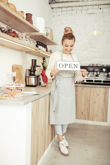 Propriétaire de la startup. Heureuse belle propriétaire de café souriante à cause de l'ouverture de son nouveau lieu.