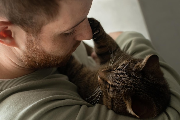 Le propriétaire tient son chat chat jouant avec son propriétaire