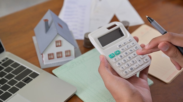 Le propriétaire utilise la calculatrice pour vérifier les dépenses de la maison.