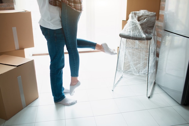 Les propriétaires de jeune couple pour la première fois célèbrent le concept du jour du déménagement, l'homme mari soulevant une femme tenant debout près de boîtes dans un nouvel appartement, une réinstallation et une hypothèque familiale