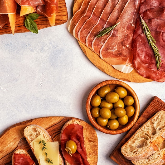 Prosciutto, fromage et olives sur des planches en bois