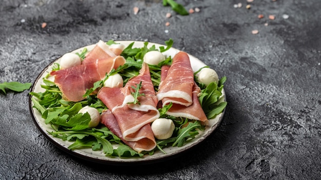 Prosciutto, jamon, mozzarella et roquette fraîche Salade d'antipasto