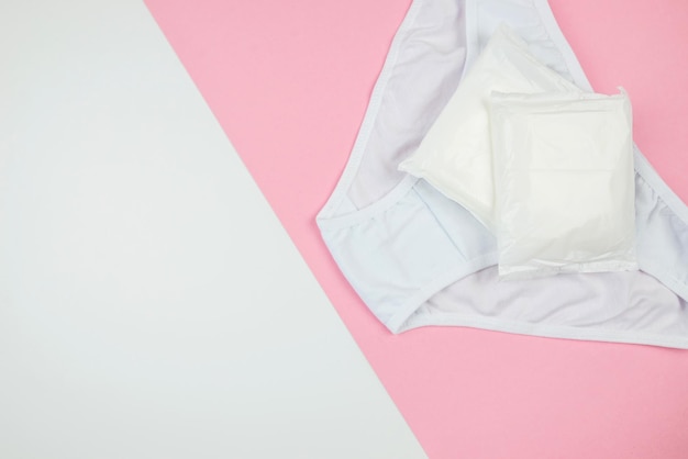 Protège-slips blancs pour femmes sur fond rose et blanc avec vue de dessus de l'espace de copie