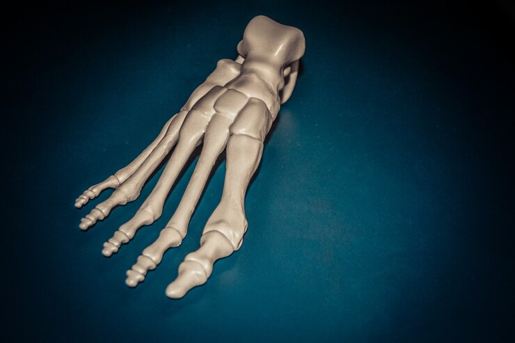 Photo prototype blanc du squelette du pied humain imprimé sur une imprimante 3d sur une surface sombre. modélisation des dépôts fondus, fdm. technologie additive moderne et progressive. concept de la révolution industrielle 4.0