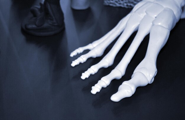 Prototype blanc du squelette du pied humain imprimé sur une imprimante 3d sur une surface sombre