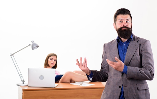 Provocation sexuelle Concept collectif de bureau Le patron barbu se tient devant une fille sexy travaillant sur un ordinateur portable Gestionnaire de bureau ou secrétaire Employée de bureau sexy Secrétaire personnelle sexy Plein de désir