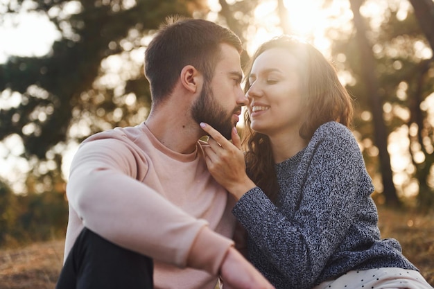 Proximité des gens Enthousiaste charmant jeune couple se reposer ensemble à l'extérieur