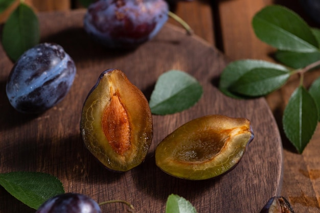 Prune coupée en deux sur une planche de bois