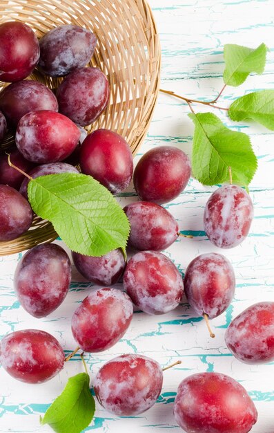 Prune dispersée du panier en osier sur la table