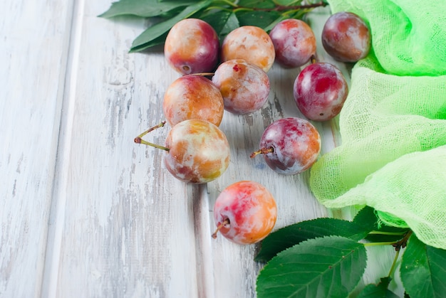 Prune fraîche dispersée sur une table en bois