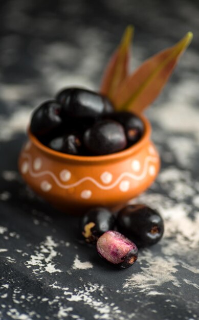 Photo prune de java syzygium cumini avec feuille sur fond texturé en pierre