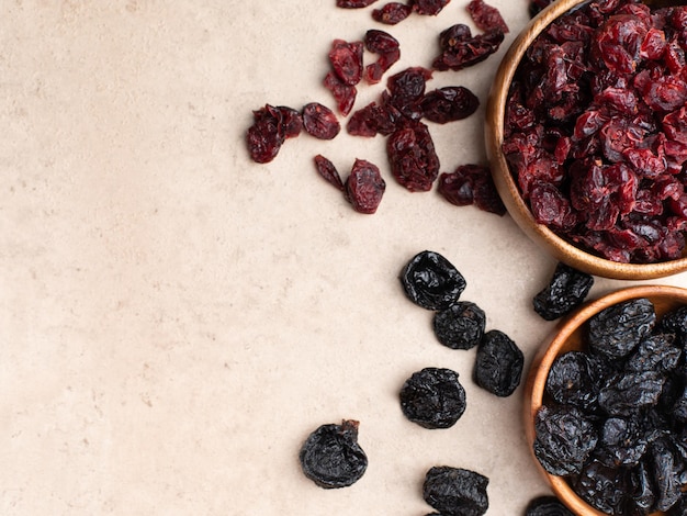 Pruneaux aux canneberges aux fruits secs sains dans un bol en bois vue de dessus flatlay