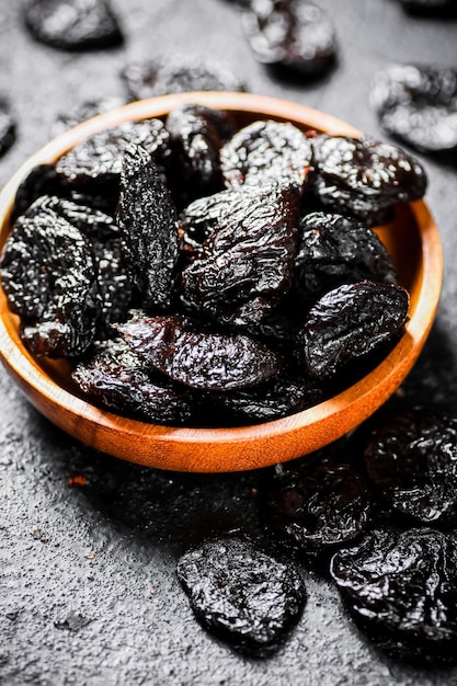 Des prunes dans une assiette en bois sur la table