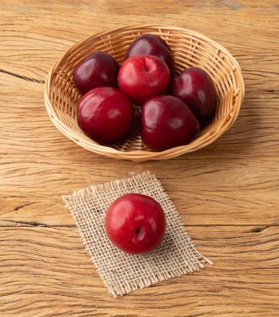 Prunes dans un panier sur une table en bois.