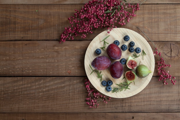 Prunes, figues et myrtilles sur plaque en bois