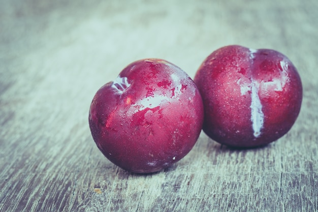 Prunes sur fond de bois avec filtre effet rétro style vintage