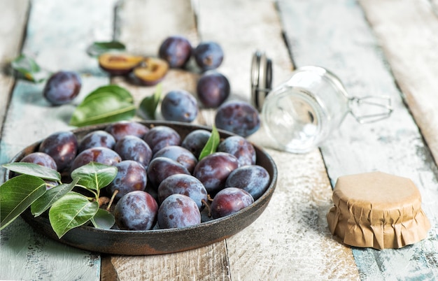 Prunes sur fond de bois rustique. Confiture marmelade préparation