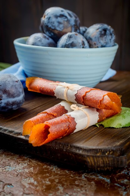 Prunes fraîchement cueillies dans un bol en poterie et pastille aux prunes