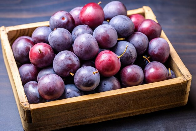 Prunes fraîches dans une boîte en bois sur un fond en bois foncé