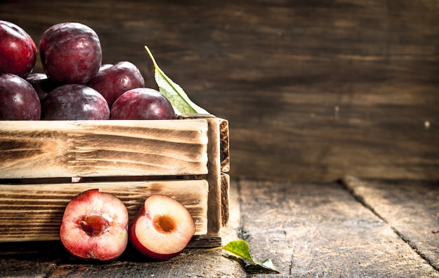 Prunes fraîches dans une boîte en bois.