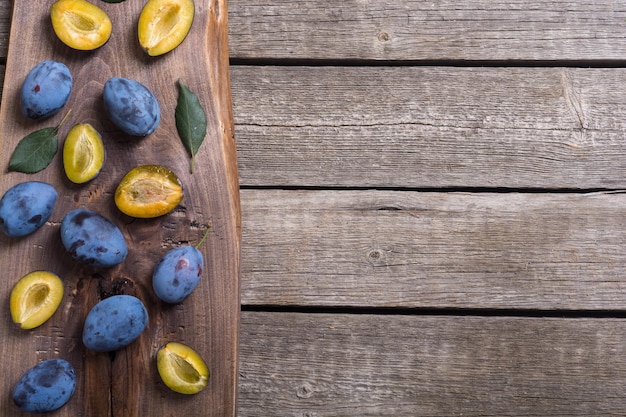 Prunes fraîches dans un bol sur une table en bois Arrière-plan de fruits