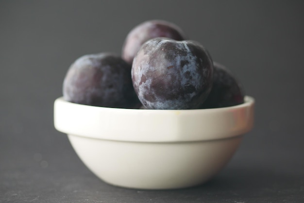 Prunes fraîches dans un bol sur la table