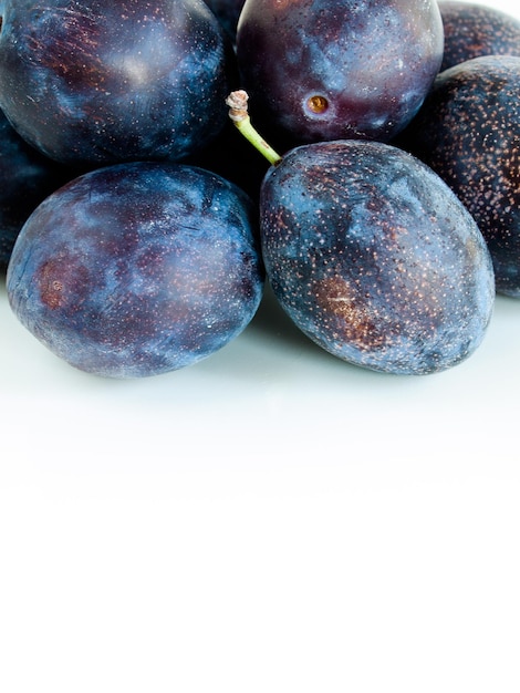 Prunes fraîches sur fond blanc.