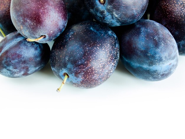 Prunes fraîches sur fond blanc.