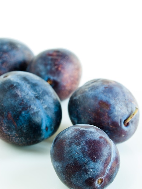 Prunes fraîches sur fond blanc.