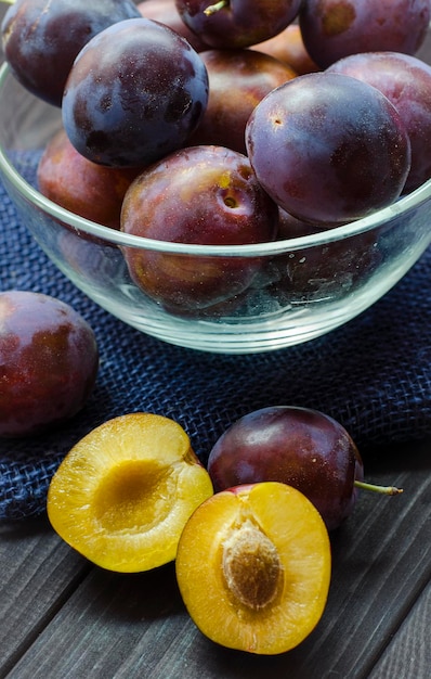 prunes fraîches mûres dans un bol sur la table