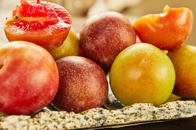 Prunes fraîches rouges et jaunes sur assiette prêtes à manger.