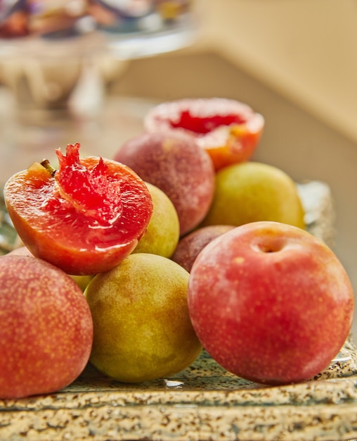 Prunes fraîches rouges et jaunes sur assiette prêtes à manger.